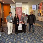 Four adults stand next to each other at the 2025 World Vaccine Congress
